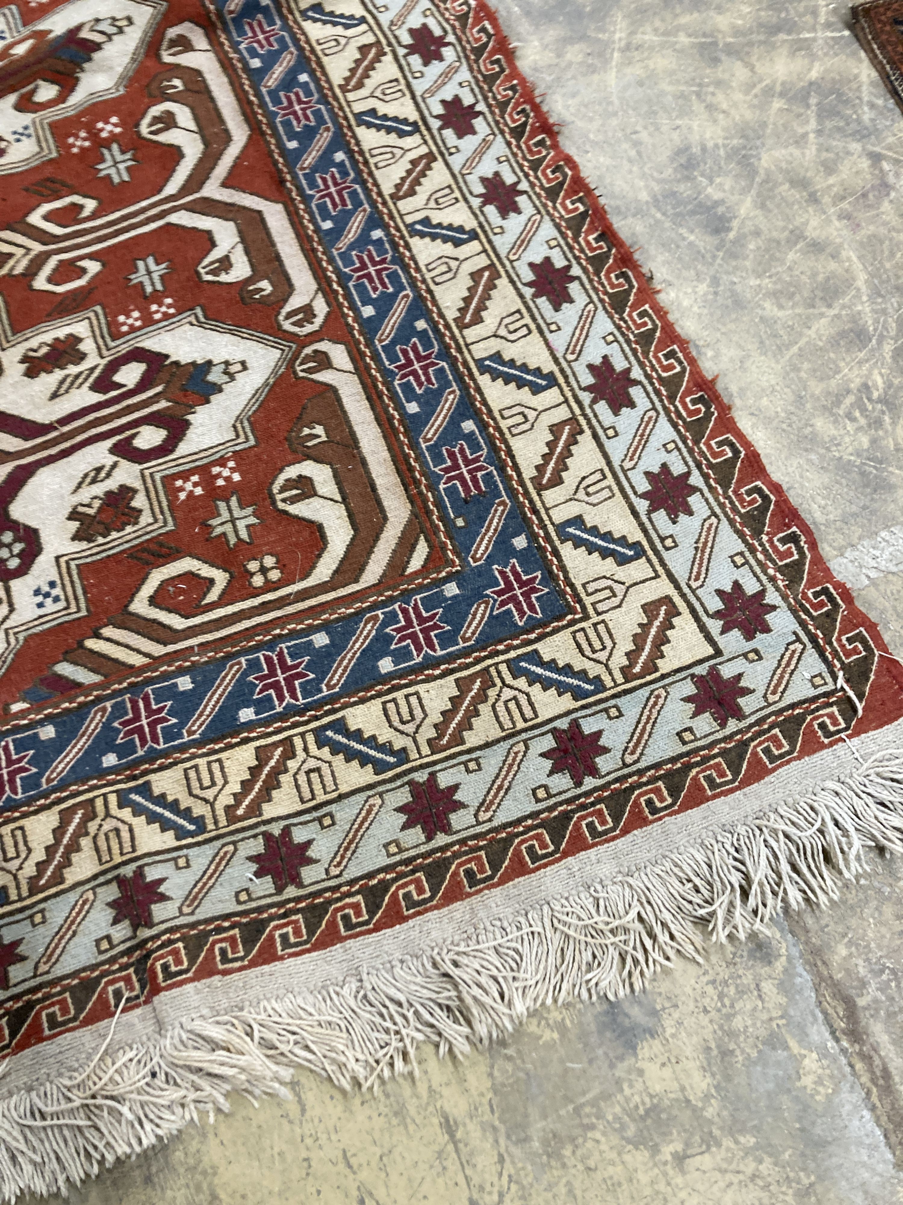 A Caucasian design red ground rug, 240 x 165 cms.